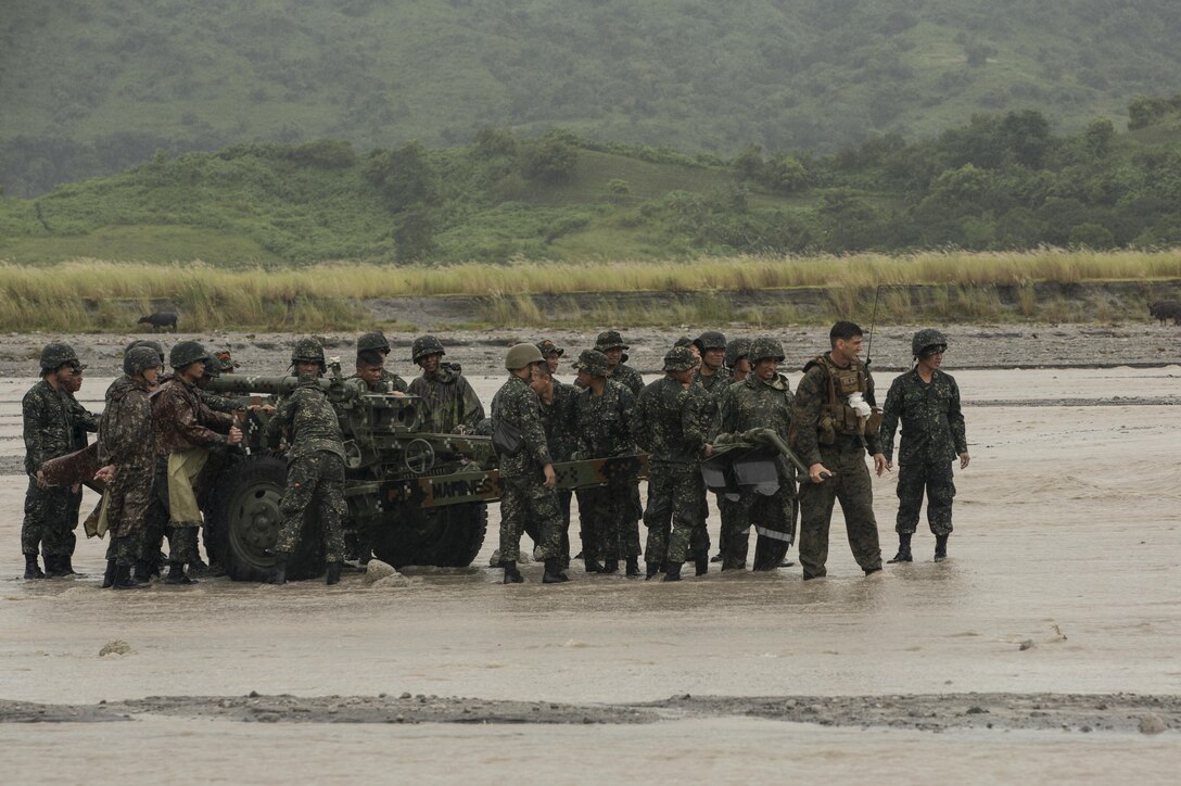 Philippine and U.S. Marines work together to prepare an M101 105mm howitzer to be towed from the riverbed during Amphibious Landing Exercise 2015 at Crow Valley, Philippines, Oct. 2, 2015. U.S. Marine Corps photo by Staff Sgt. Carl Atherton