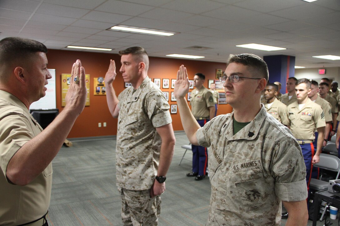 Brig. Gen. James W. Bierman reaffirms the oath of enlistment with Sgt. Joshua S. Whittington (right) and Sgt. Curtis W. Paul (left) in Lansing, Mich., Oct. 6, 2015. Both Marines are recruiters with Recruiting Station Lansing and were promoted to staff sergeant after the oath.