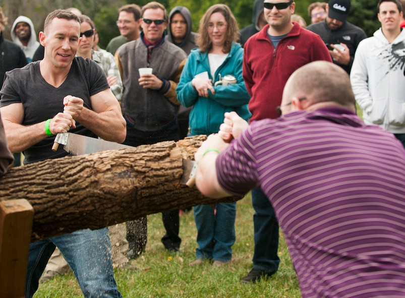 Capt. Joshua Loomis and Matthew Saam National Air and Space intelligence Center staff, compete in a log sawing contest during the center's 47th Annual Oktoberfest celebration at Bass Lake, Oct. 2, 2015. NASIC Airmen compete in Oktoberfest Cup competitions to earn center bragging rights; events consist of a keg toss, log sawing contest, beer jug relay, and beer tasting. (U.S. Air Force photo by Senior Airman Samuel Earick)