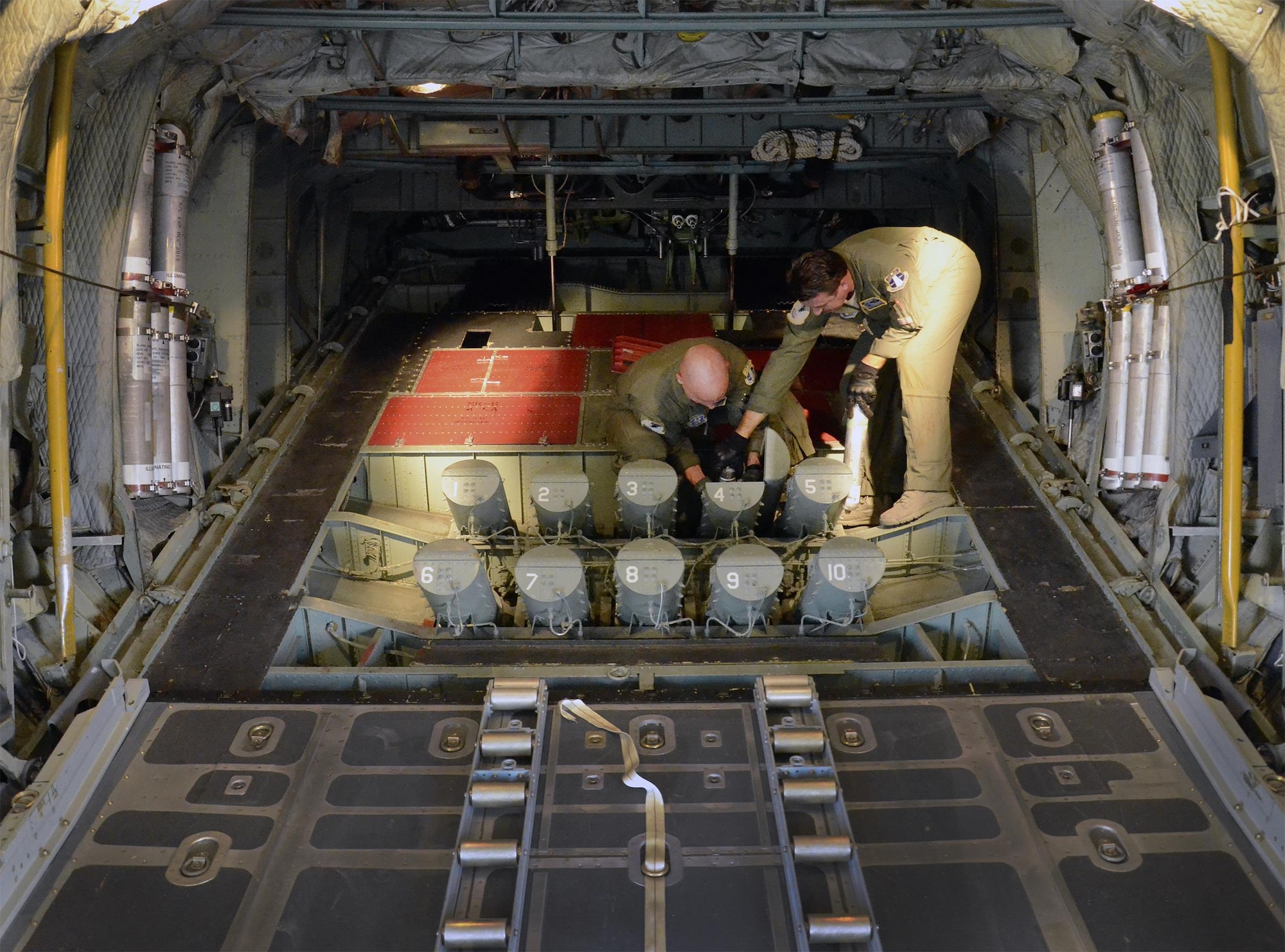 Air Force Reserve aircrew members load cannisters of sea dye into the flare launcher system of an HC-130P/N King aircraft prior to launching a search-and-rescue mission. The dye, which spreads into a large, bright flourescent green patch in seawater, is used to mark the location of a survivor during a search operation. The reservists are members of the 920th Rescue Wing, the Air Force Reserve’s only rescue unit. (U.S. Air Force photo/Master Sgt. Paul Flipse) 