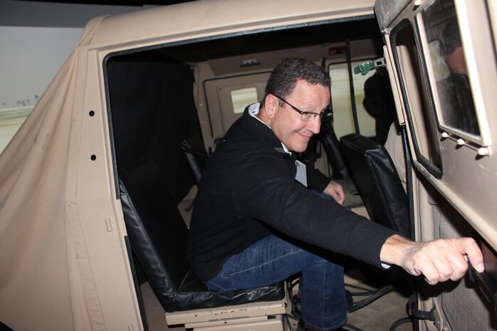 Robert Eckert, of Alexandria, Va., a regional director for Ameriprise Financial, climbs into the backseat of a model humvee in the Virtual Combat Convoy Trainer. Eckert visited Camp Upshur with a group of Marine Corps Association members and guests on Oct. 2.