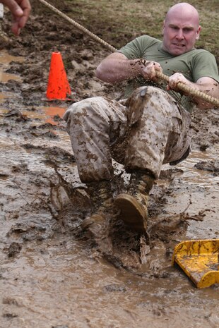A Marine slides through the mud during the tug-of-war event of the Marine Corps Base Quantico Field Meet held at Butler Stadium on March 21, 2014