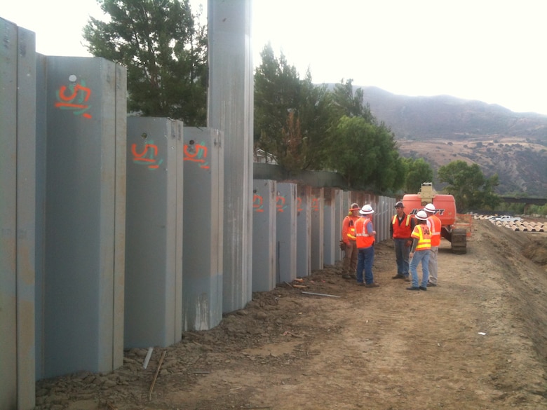 Corps employees and contractors discuss the status of piling installation along a section of Reach 9 of the Santa Ana River just downstream from Prado Dam. The pilings are part of bank protection along the flood risk reduction project.