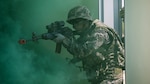 Republic of Korea Marine Cpl. Geon Shin breaches a building alongside U.S. Marines under smoke concealment during Korean Marine Exchange Program 15-12 at Gunha-Rhi, Gimpo, Republic of Korea, Sept. 17, 2015. KMEP 15-12 is a bilateral training exercise that enhances the ROK and U.S. alliance, promotes stability on the Korean Peninsula and strengthens ROK and U.S. military capabilities and interoperability. Shin, from Mokpo, ROK, is a rifleman with 1st Company, 11th Battalion, 1st Regiment, 2nd Marine Division. The U.S. Marines are with Fox Company, 2nd Battalion, 3rd Marine Regiment, currently assigned to 4th Marine Regiment, 3rd Marine Division, III Marine Expeditionary Force under the unit deployment program. (U.S. Marine Corps photo by Cpl. Tyler S. Giguere/ Released)