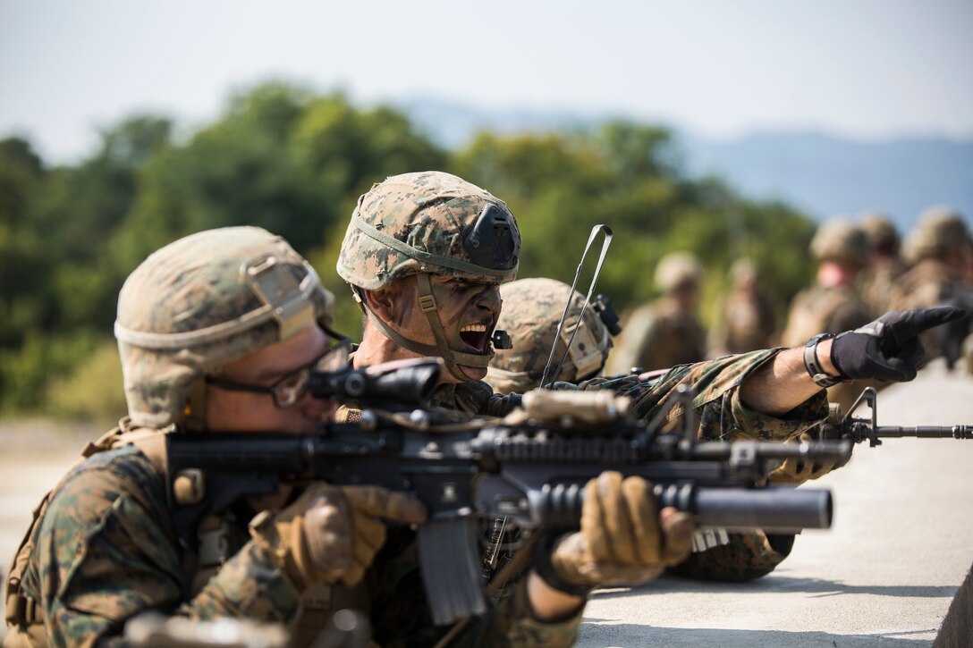 U.S. Marine 1st Lt. Matt Shibata, center, directs gunfire during Korean Marine Exchange Program 15-12 at Rodriguez Landing Zone, Republic of Korea, Sept. 25, 2015. Alongside their ROK counterparts, the Marines took over a fortified enemy hill to provide security for other Marines to press forward. KMEP 15-12 is a bilateral training exercise that enhances the ROK and U.S. alliance, promotes stability on the Korean Peninsula and strengthens ROK and U.S. military capabilities and interoperability. Shibata, from Honolulu, Hawaii, is with Fox Company, 2nd Battalion, 3rd Marine Regiment, currently assigned to 4th Marine Regiment, 3rd Marine Division, III Marine Expeditionary Force under the unit deployment program. 