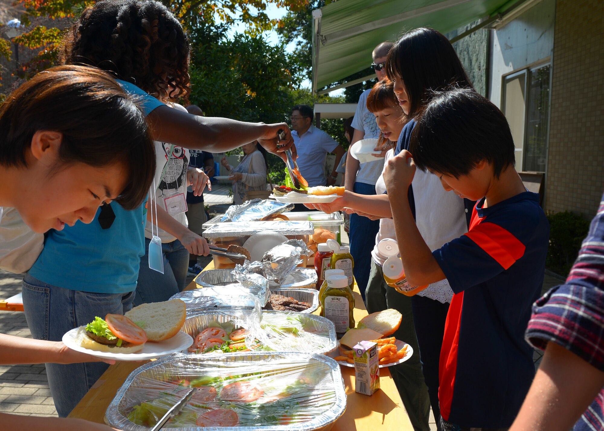 Volunteers from Yokota Air Base, Japan, serve food at Shiseigakuen orphanage in Tokyo, Japan, Oct. 3, 2015. Kim Do, 374th Force Support Squadron marketing director, and Mendy Ornellas, University of Maryland University College receptionist, invited Yokota Airmen to join them in connecting with the Tokyo community by volunteering at the orphanage. (U.S. Air Force photo by Airman 1st Class Elizabeth Baker/Released)