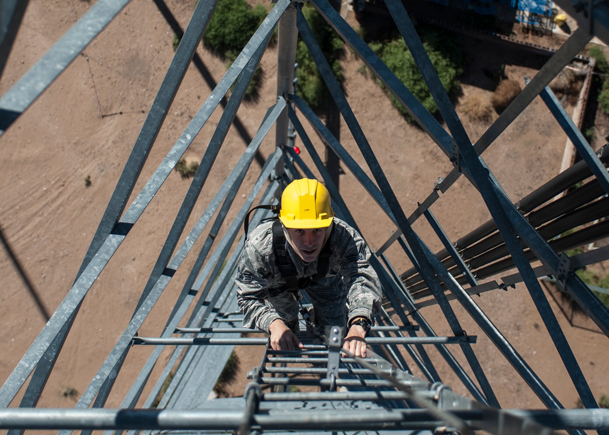 Senior Airman James Vrtis, 57th Operations Support Squadron airfield systems technician, ascends a ground-to-air radio tower at the Airfield Systems Maintenance compound on Nellis Air Force Base, Nev., Oct. 6, 2015. Airfield systems technicians install, remove, relocate, modify, deploy and maintain fixed and mobile meteorological, navigation and air traffic control ground-to-air radio systems. (U.S. Air Force photo by Staff Sgt. Siuta B. Ika)