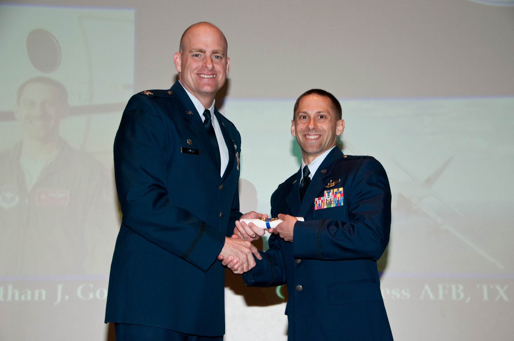 Then 2nd Lt. Jonathan Golden receives his Air Force Pilot rating from Col. Darren James at the base theater at Vance Air Force Base, Oklahoma, April 5, 2013. Capt. Golden died in a C-130J crash in Jalalabad, Afghanistan, Oct. 2. James served as the 71st Flying Training Wing commander from 2012 to 2014. (U.S. Air Force photo / Terry Wasson)