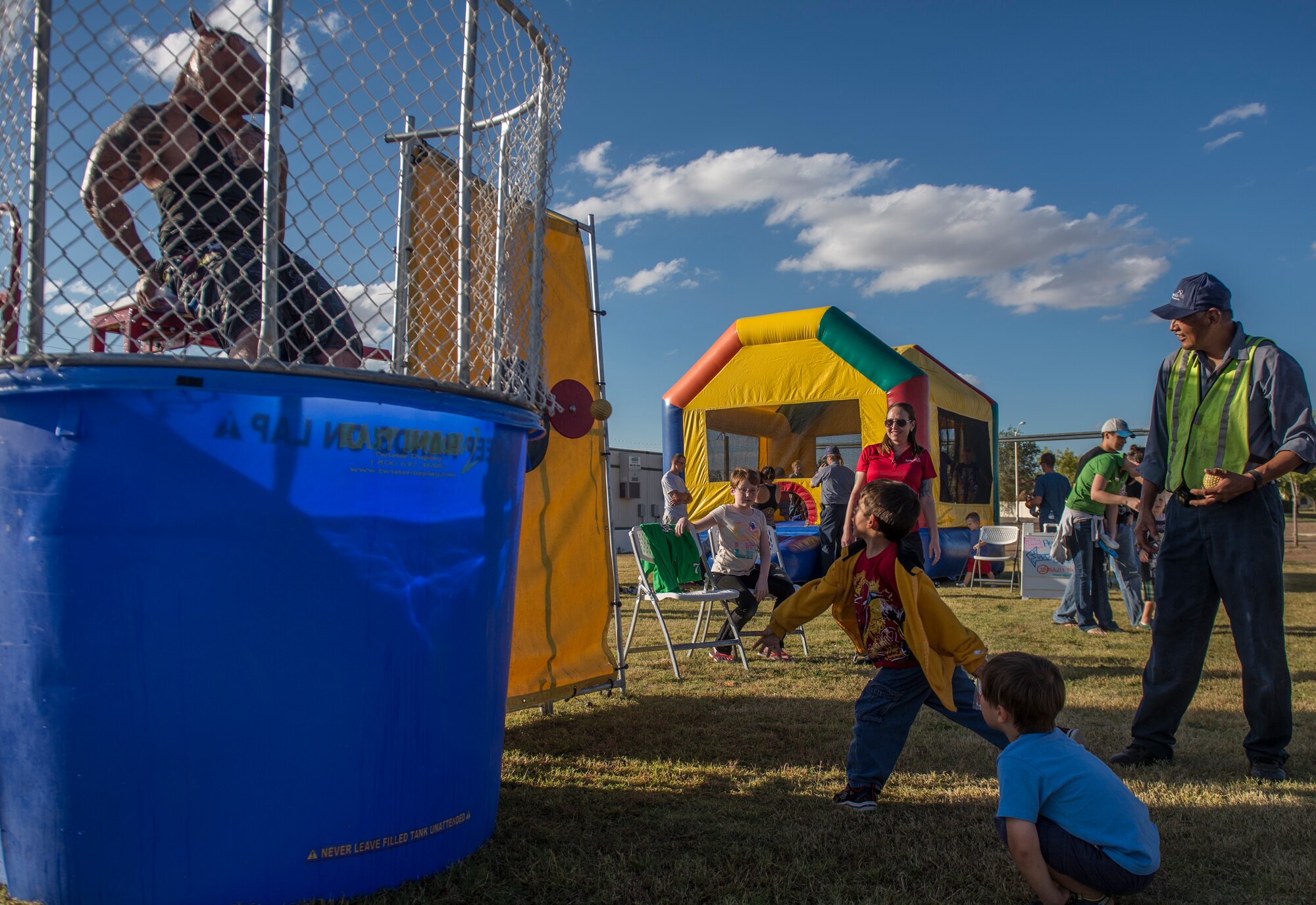 A Team Holloman dependent aims for the target at the dunk tank during the annual National Night Out event hosted by Soaring Heights Communities at Holloman Air Force Base, N.M., Oct. 6. This is the eighth year Soaring Heights has hosted the event and brought together law enforcement, fire protection and community support agencies to provide Holloman residents information and child safety material. Every year, Holloman Airmen and local community members gather at Soaring Heights which offers them food, music and various events for children to enjoy. (U.S. Air Force photo by Senior Airman Aaron Montoya)