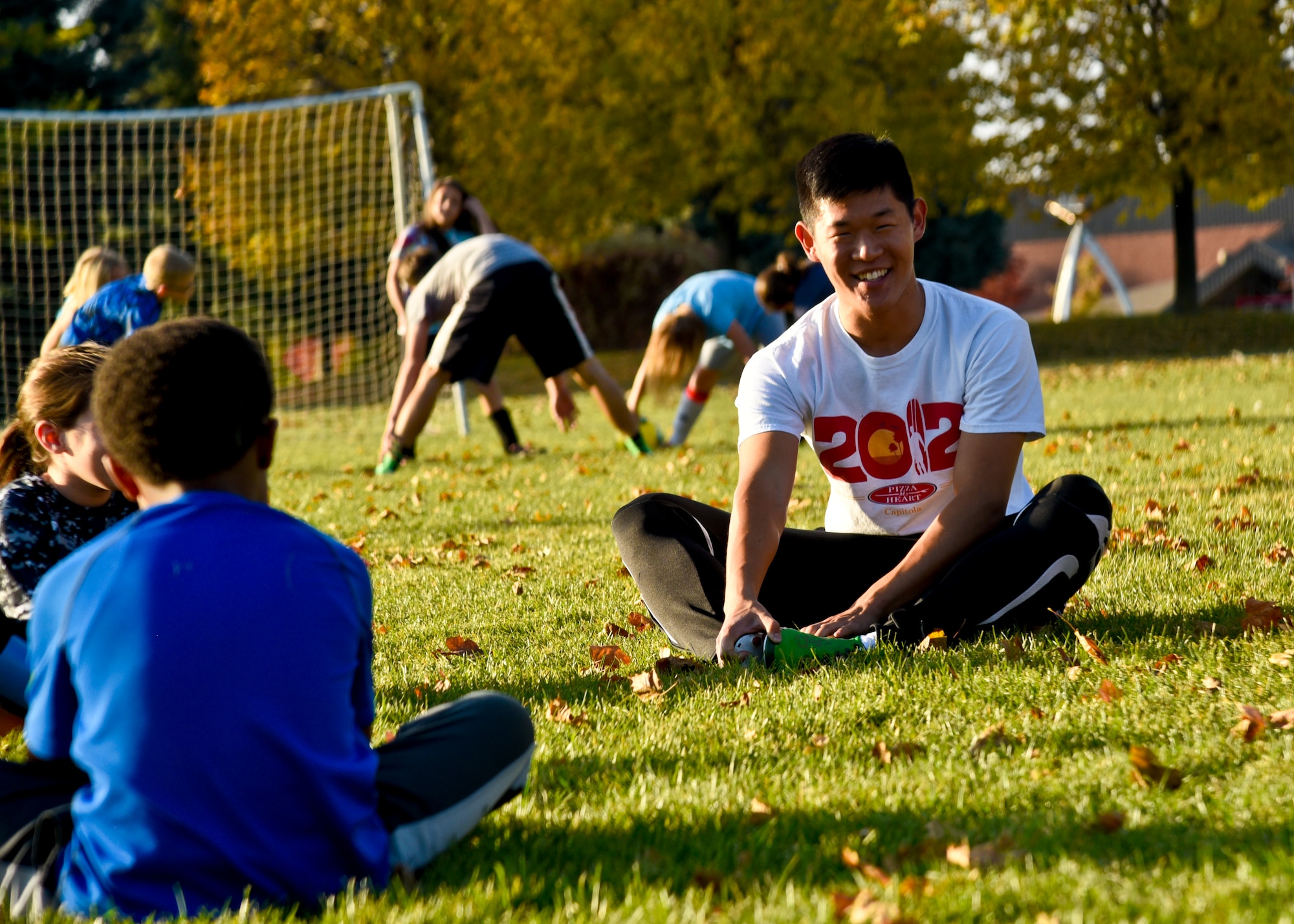 Senior Airman Frederick Chung, 92nd Maintenance Squadron isochronal inspection crew chief, stretches with his team before practice Oct. 5, 2015, at Fairchild Air Force Base, Wash. Chung volunteers in his free time as a youth soccer coach for the base youth center. This is his fourth season and currently coaches 9- and 10-year-olds on a co-ed team. (U.S. Air Force photo/Airman 1st Class Taylor Bourgeous)