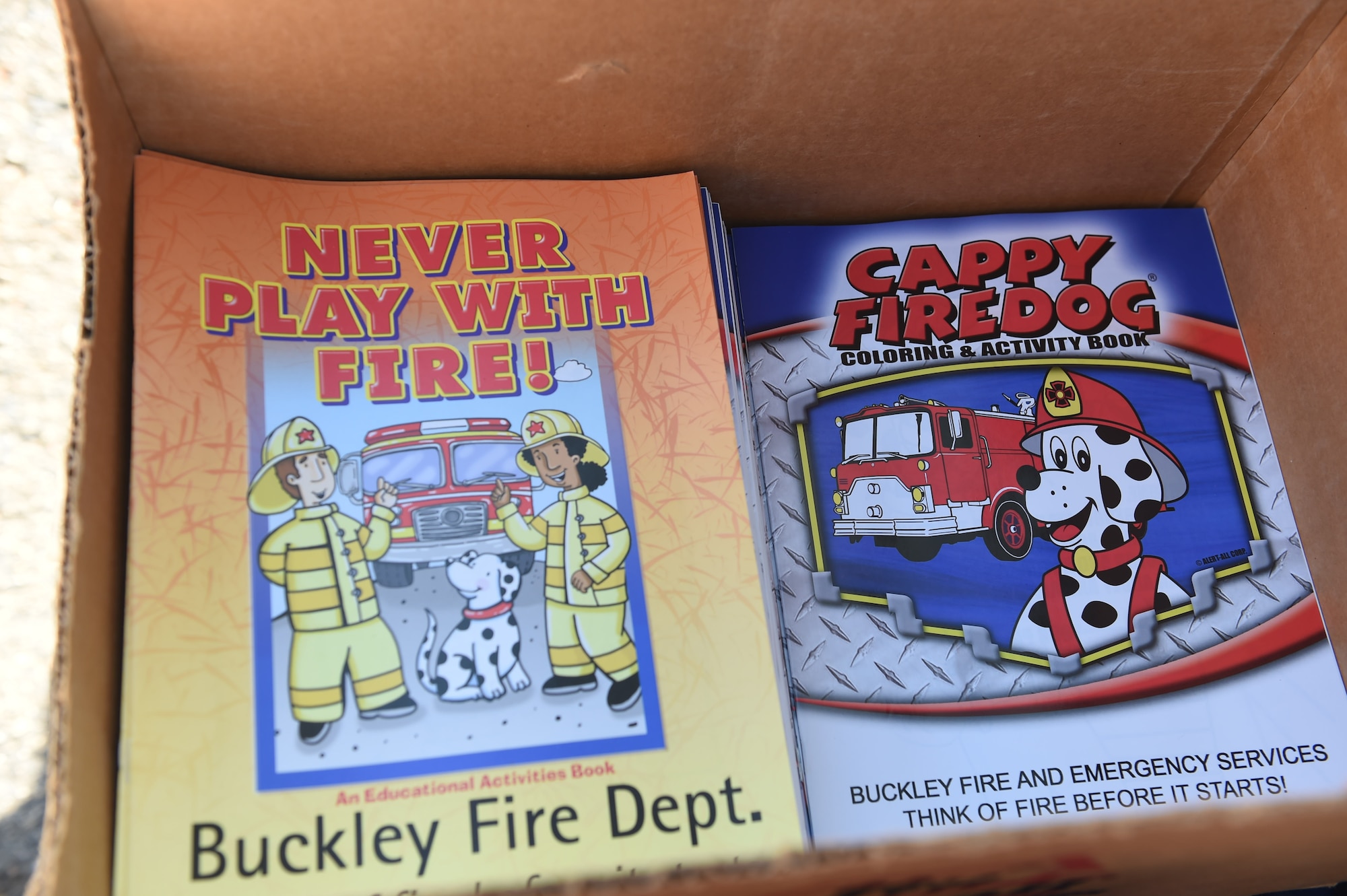 Coloring books were given to children from the Crested Butte Child Development Center during a visit by the Buckley Fire Department Oct. 7, 2015, on Buckley Air Force Base, Colo. The fire department visited both CDCs on base to spread the word about Fire Prevention Week. For the visit, the children got to meet Sparky the Fire Dog, look at fire trucks, and take home coloring books and plastic fire helmets. (U.S. Air Force photo by Airman 1st Class Samantha Meadors/Released)