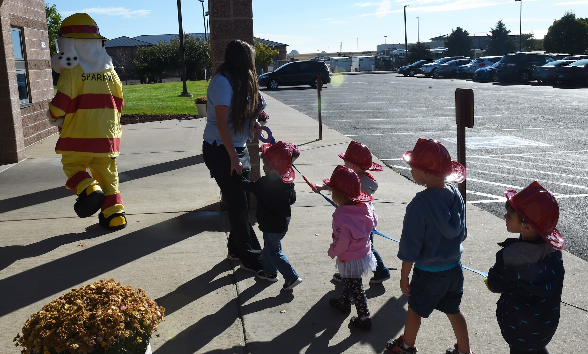 Children from the Crested Butte Child Development Center march behind Sparky the Fire Dog Oct. 7, 2015, on Buckley Air Force Base, Colo. Sparky was part of a visit from the Buckley Fire Department to both CDCs on base to spread the word about Fire Prevention Week. The fire department also brought fire trucks for the children to look at, along with plastic fire helmets and coloring books for them to take home. (U.S. Air Force photo by Airman 1st Class Samantha Meadors/Released)