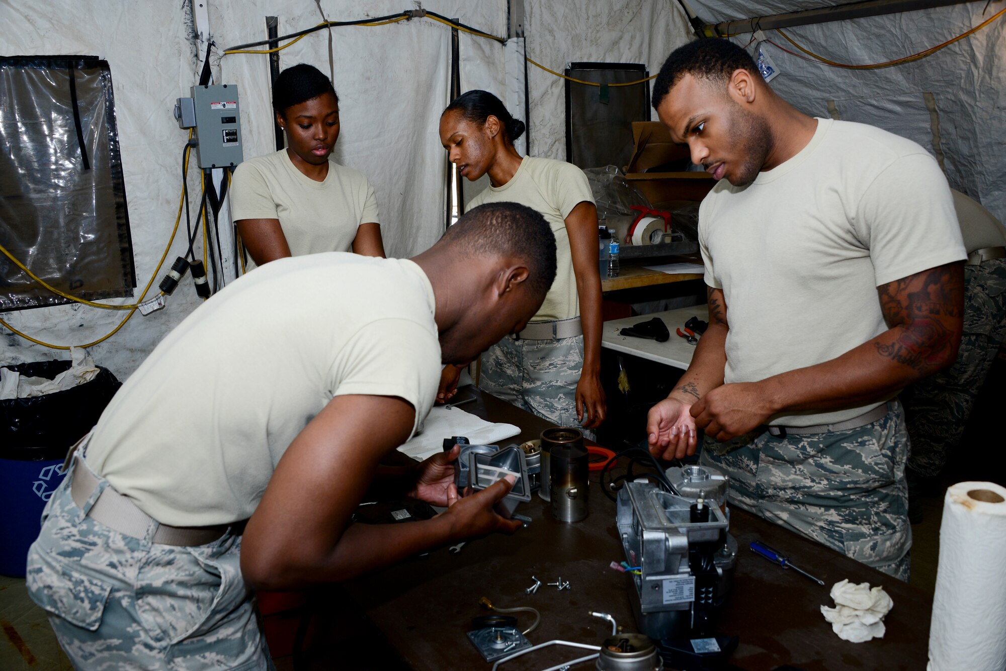 U.S. Airmen from the 355th Force Support Squadron work on reassembling Babington Airtronic burners at Davis-Monthan Air Force Base, Ariz., Sept. 30, 2015. Airmen from D-M, Luke AFB, Ariz., and Nellis AFB, Nev., attended the expeditionary kitchen training. The training was dedicated to FSS Airmen learning how to operate, repair and maintain equipment in a Single Pallet Expeditionary Kitchen. (U.S. Air Force photo by Airman 1st Class Mya M. Crosby/Released)