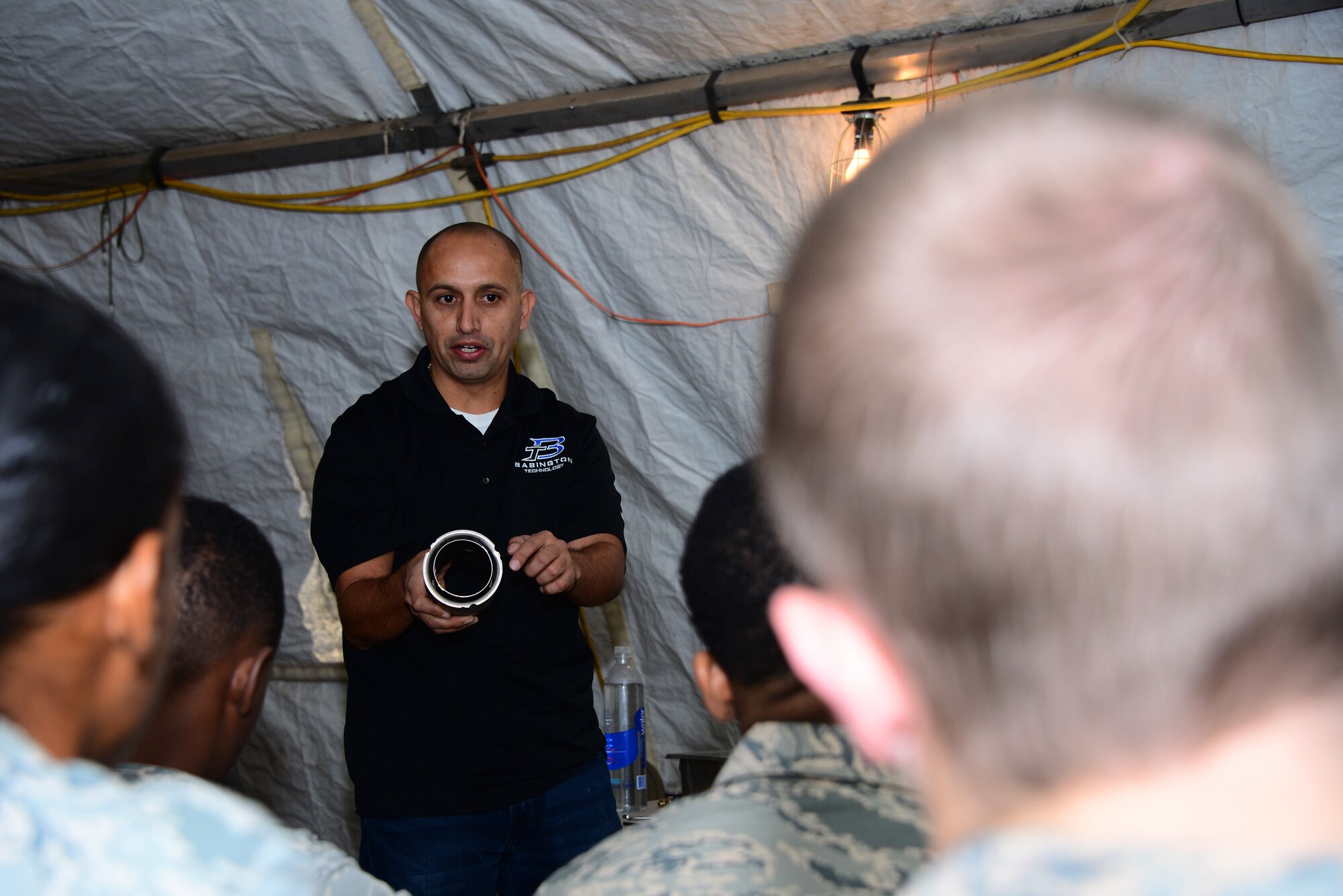 Ramiro Andrade, Babington Technology engineer, lectures on how to properly take apart a Babington Airtronic burner to 355th Force Support Squadron Airmen at Davis-Monthan Air Force Base, Ariz., Sept. 30, 2015. Andrade came to D-M to teach the Airmen how to operate, repair and maintain equipment that they would use in a deployed environment. (U.S. Air Force photo by Airman 1st Class Mya M. Crosby/Released)
