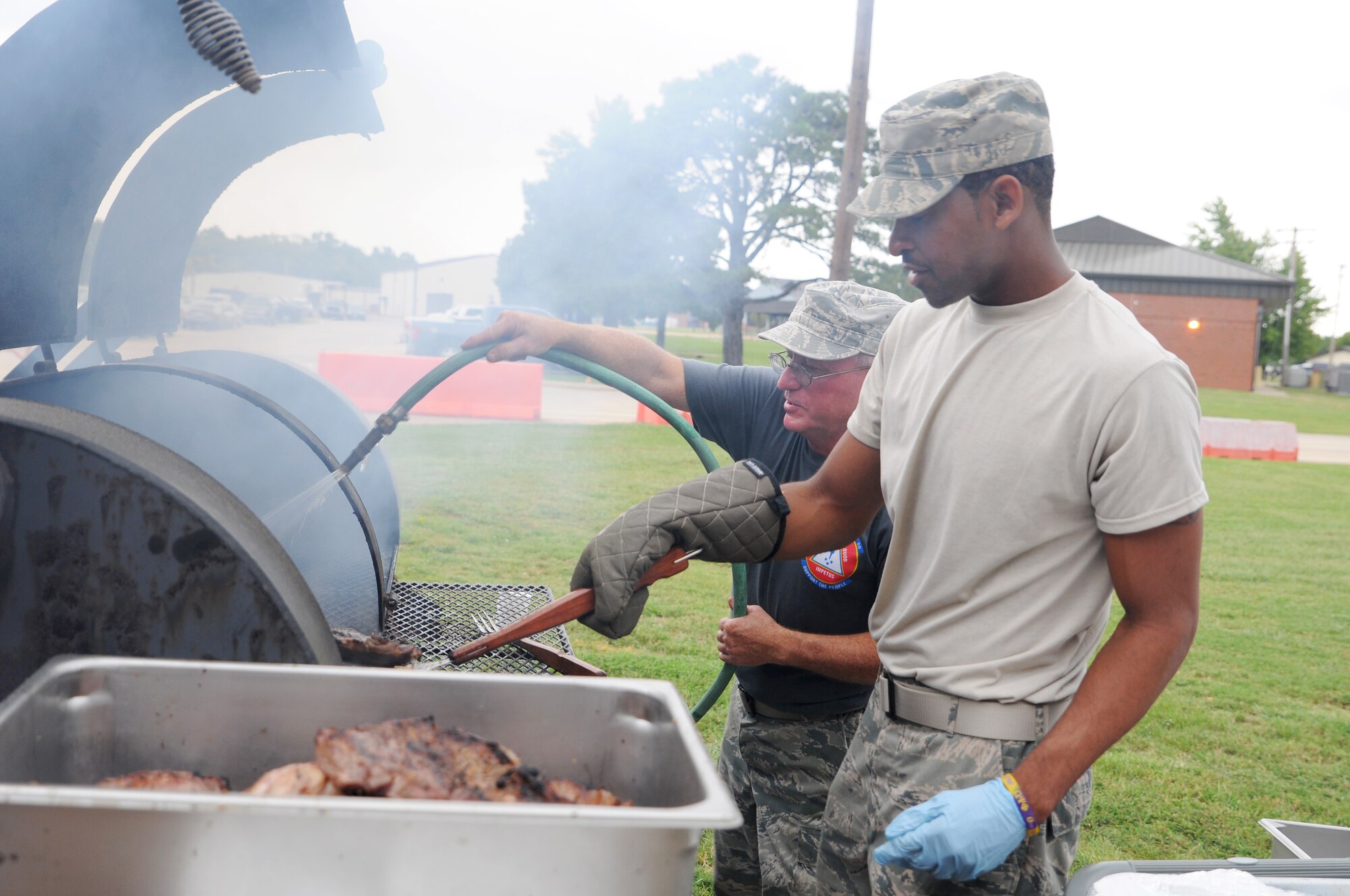 Tech. Sgt. Ricky Brown and Senior Airman Antoine Leaks, 188th Force Support Squadron, prepare a surf and turf meal Sept. 20, 2015 by cooking steaks on a grill at Ebbing Air National Guard Base, Fort Smith, Ark. The 188th Wing’s surf and turf meal is an annual tradition provided at the end of the fiscal year. (U.S. Air National Guard photo by Senior Airman Cody Martin/Released)