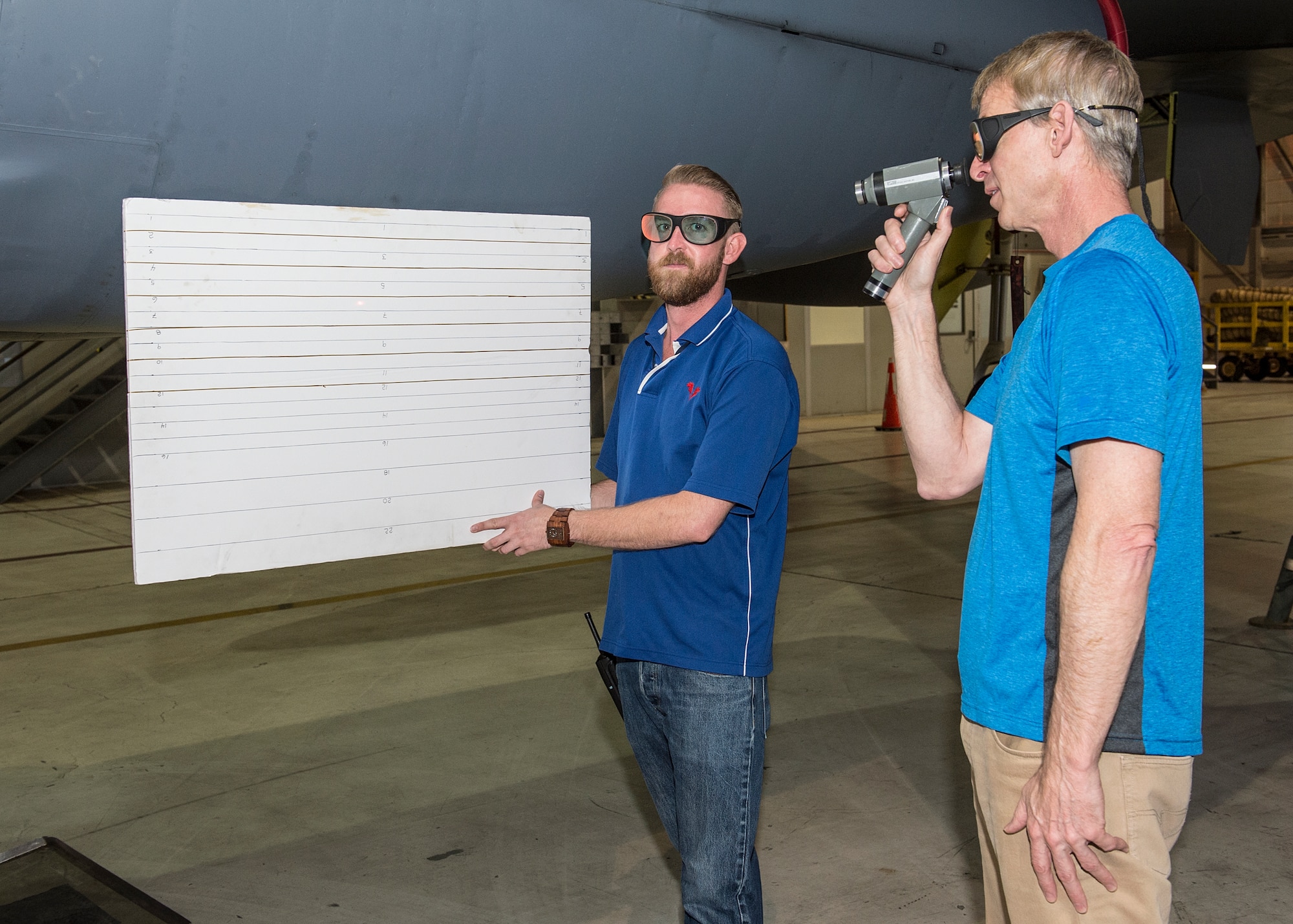 John McIntrye, 419th Flight Test Squadron sensor engineer, holds a laser target board during a laser mask zone test while Perry Choate, 419th FLTS electro optics engineer, views the laser spot. The 419th FLTS at Edwards AFB recently executed ground laser testing on the B-52H aircraft. The bomber is integrating the LITENING targeting pod under the right wing. Operational B-52 aircrews have requested additional targeting pod resources to maintain precision weapon delivery and to provide air support for troops on the ground. (U.S. Air Force photo by Edward Cannon)
