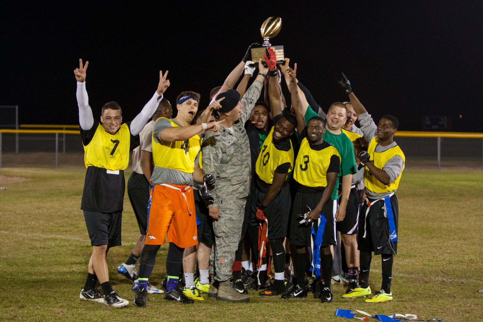 The 790th Missile Security Forces Squadron’s intermural flag football team celebrates their victory over the Tactical Response Force team Oct. 5, 2015 on a softball field near the Freedom Hall Fitness Center, F.E. Warren Air Force Base, Wyo. The 790th team won by a single point, scored with just minutes left in the game. (U.S. Air Force photo by Lan Kim)