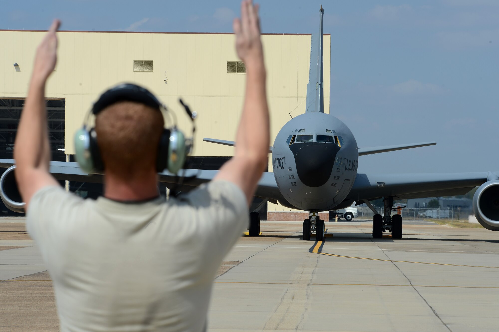 A crew chief from Seymour Johnson Air Force Base, North Carolina, gives a departure signal to the pilots of a KC-135 Stratotanker assigned to the 916th Air Refueling Wing at Barksdale Air Force Base, La., Oct. 6, 2015. More than 60 aircraft were evacuated here to avoid damage from Hurricane Joaquin. (U.S. Air Force photo/Senior Airman Joseph A. Pagán Jr.)