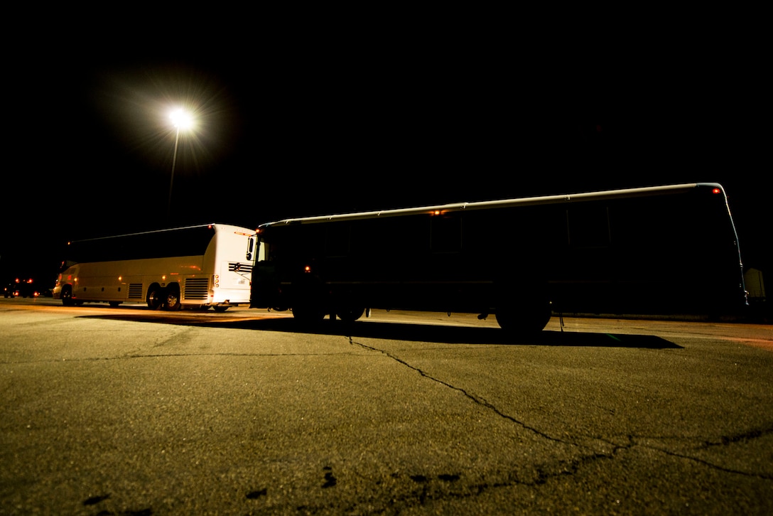 Buses transporting U.S. Air Force and Virginia Air National Guard Airmen returning from a deployment depart the flight line at Langley Air Force Base, Va., Oct. 5, 2015. During the six-month deployment, approximately 200 Service members from the 94th and 149th Fighter Squadrons provided support and stability to various regions under Operation Inherent Resolve. (U.S. Air Force photo by Senior Airman Kayla Newman/Released)