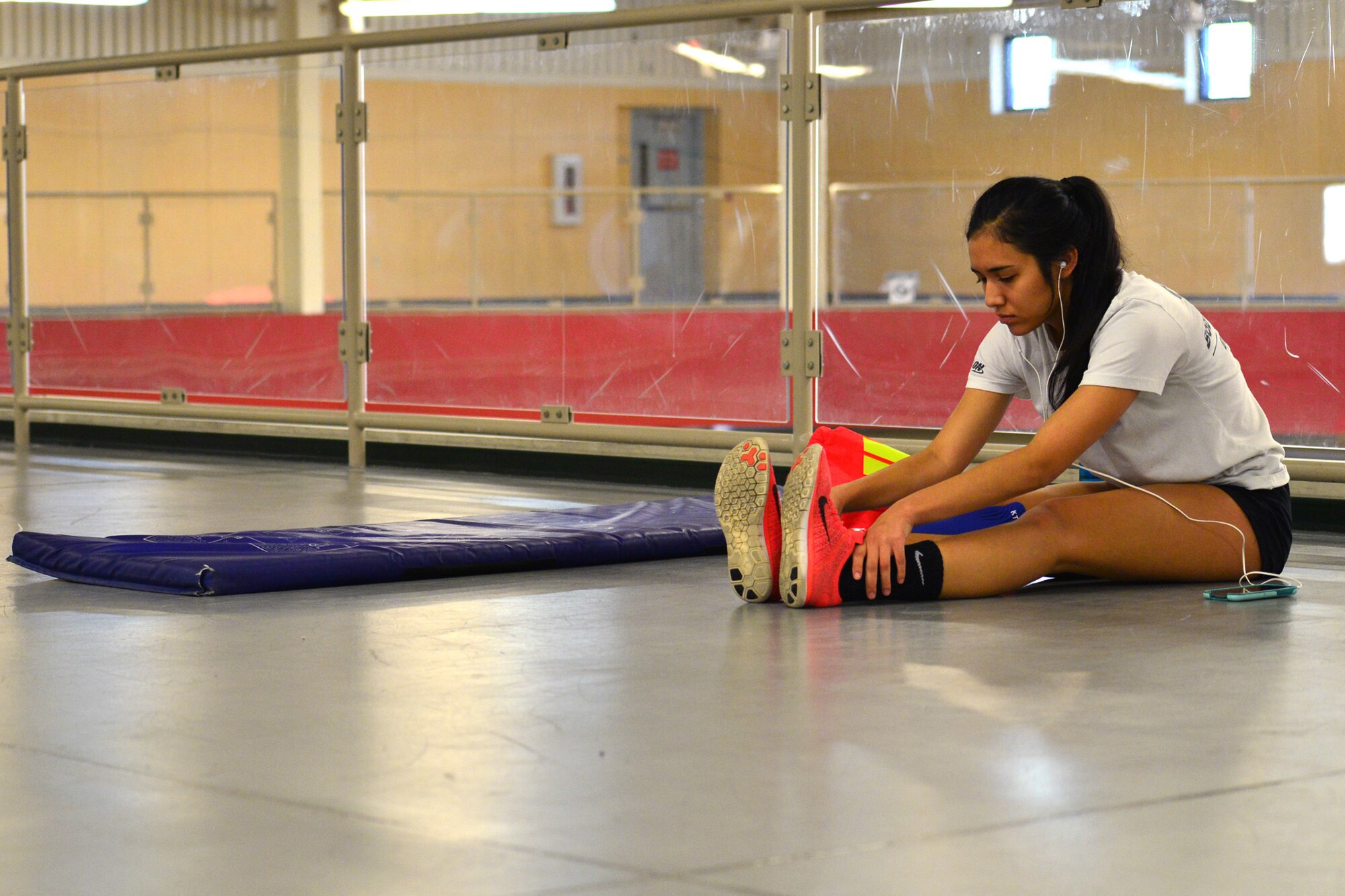Airman 1st Class Marissa Martinez, 341st Force Support Squadron missile chef, stretches before running on the indoor track Sept 30, 2015, at Malmstrom Air Force Base, Mont. Martinez uses running to clear her mind and relieve stress from life’s day stressors. (U.S. Air Force photo/Airman Daniel Brosam)