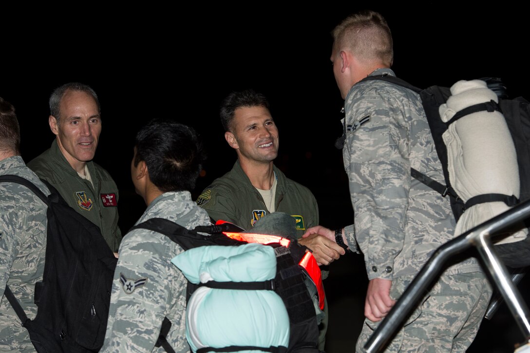 U.S. Air Force Cols. Pete Fesler, 1st Fighter Wing commander, and Robert Grey, 192nd FW commander, greet Airmen returning from a deployment at Langley Air Force Base, Va., Oct. 5, 2015. Approximately 200 Service members returned from a six-month deployment to the Middle East. (U.S. Air Force photo by Senior Airman Kayla Newman/Released)