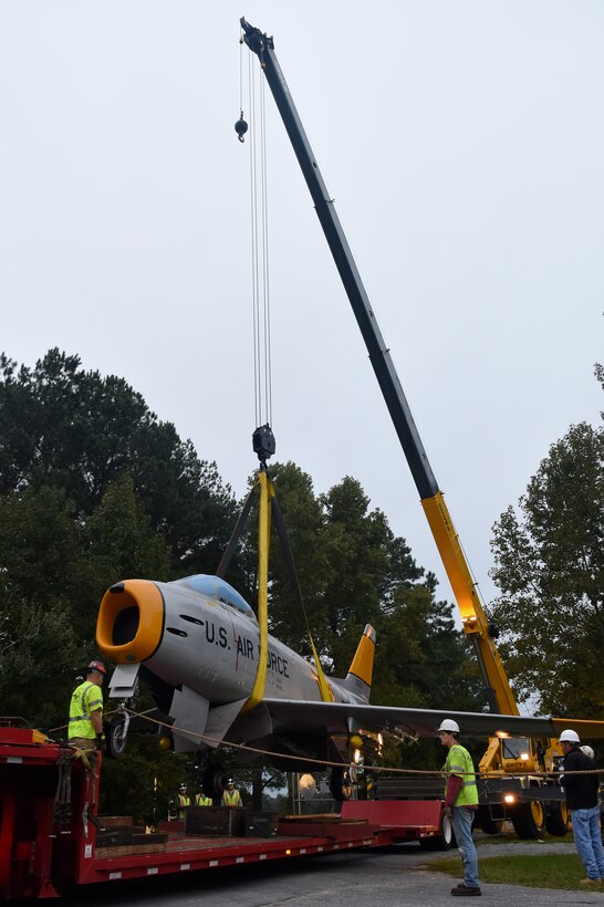 Members of the 4th Civil Engineer Squadron heavy equipment and 4th Equipment Maintenance Squadron repair and reclamation shops lower a restored F-86H Sabre onto a trailer, Oct. 6, 2015, at Seymour Johnson Air Force Base, North Carolina. Members from the installation handed off the jet to city contractors who returned it to its display at the Goldsboro Police Department. (U.S. Air Force photo/Senior Airman Aaron J. Jenne)