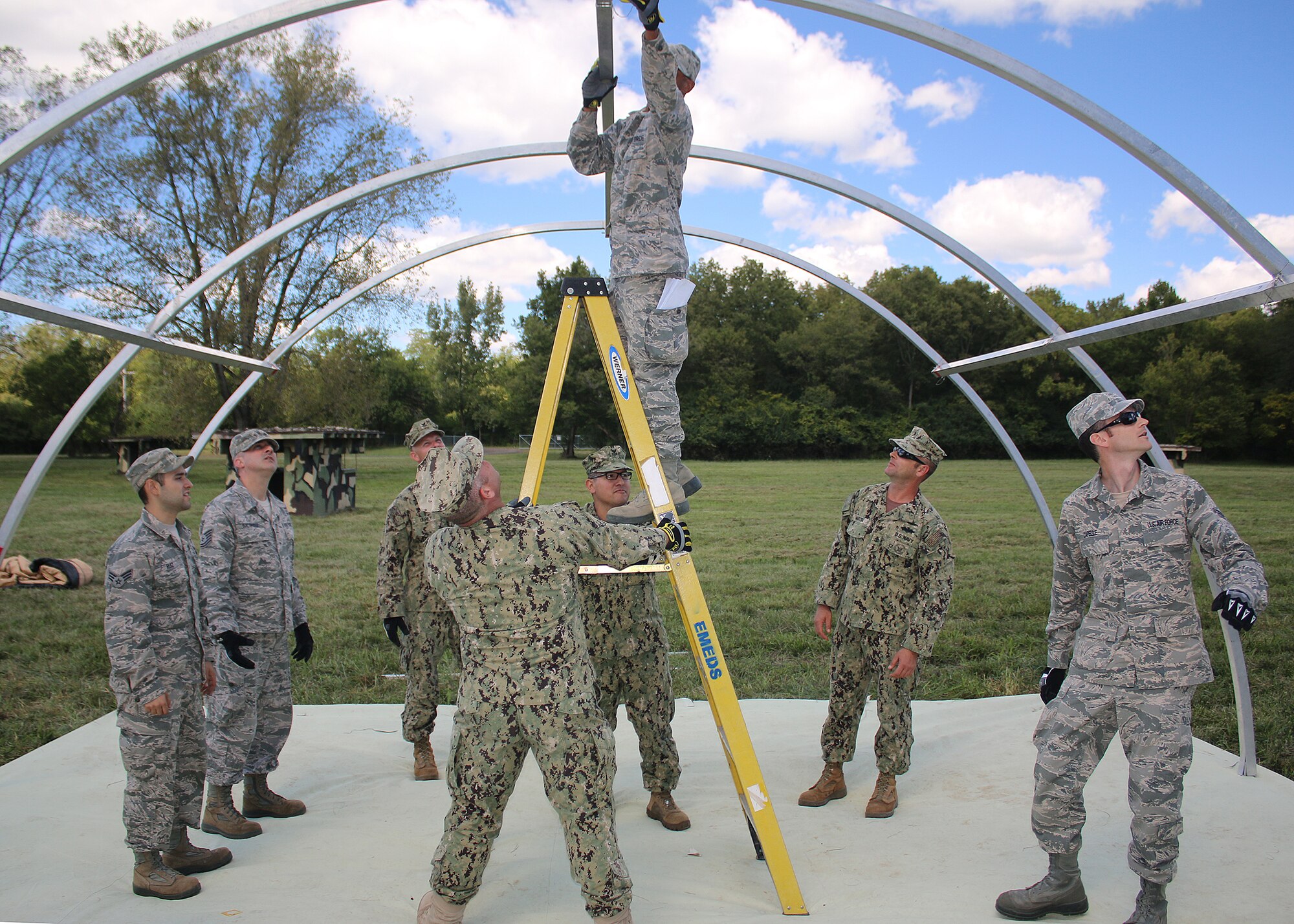 WRIGHT-PATTERSON AIR FORCE BASE, Ohio –Members of the 445th Civil Engineering Squadron and Sailors from Navy Cargo Handling Battalion 10 work to erect an Alaskan tent during a bivouac training exercise at the Warfighter Training Center Sept. 13, 2015. The Alaskan is one of many types of tents used on deployments. During the three days of training, service members covered a wide array of topics ranging from tent set-up, damage assessment response, and land navigation, to radio communications, attack preparation, and self-aid buddy care.  (U.S. Air Force photo /Tech. Sgt. Patrick O’Reilly)

