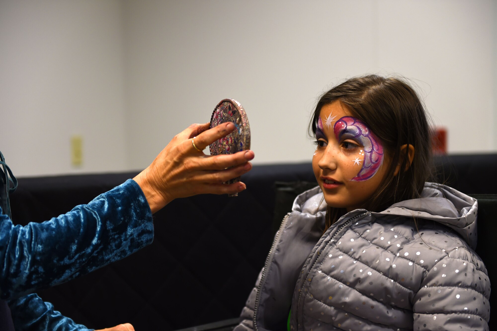 A young girl gets her face painted during the deployed family dinner at the Chapel Support Center on Joint Base Lewis-McChord, Wash., Oct. 2, 2015. The girl, whose father is deployed, attended the event with her mom along with more than 250 McChord families. (U.S. Air Force photos/Senior Airman Naomi Griego)