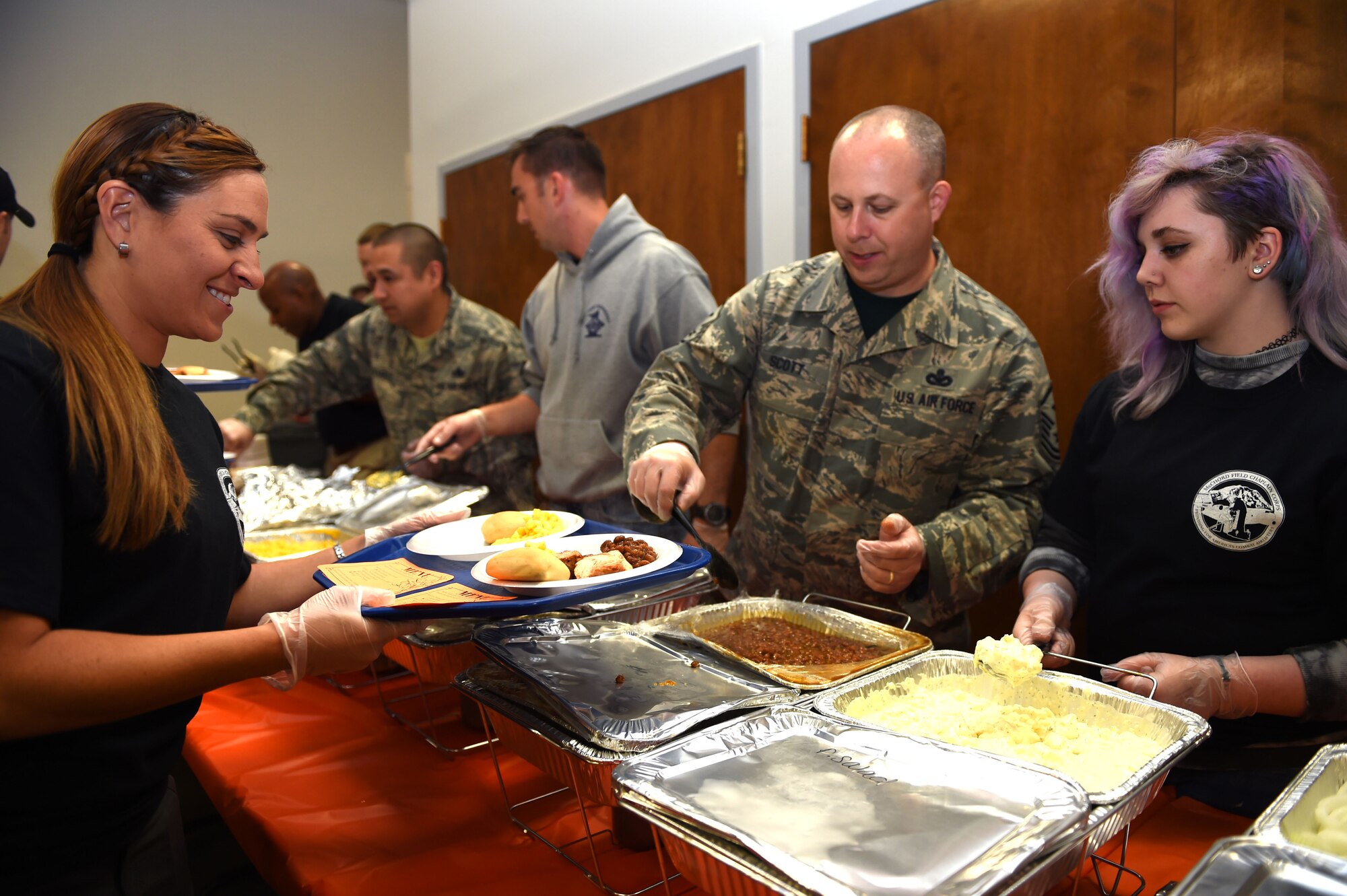 Volunteers prepare plates to serve to families during the deployed family dinner at the Chapel Support Center on Joint Base Lewis-McChord, Wash., Oct. 2, 2015. Nearly 90 volunteers supported the event which had an attendance of 250 family members. (U.S. Air Force photos/Senior Airman Naomi Griego) 