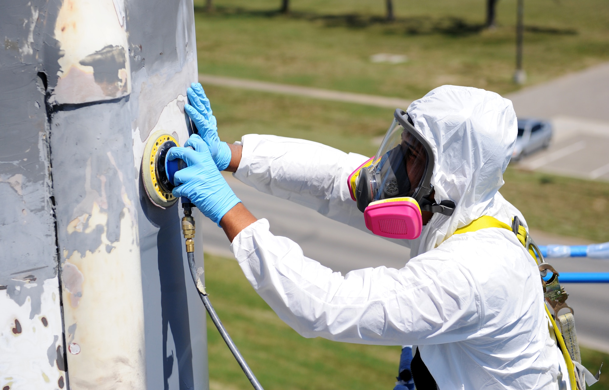 Senior Airman Carlos Colon, 509th Maintenance Squadron low observable technician, sands a Minuteman II Missile static display at Whiteman Air Force Base, Mo., Aug. 21, 2015. The missile was sanded, primed and then painted as part of the restoration process. (U.S. Air Force photo by Airman 1st Class Michaela R. Slanchik/Released)