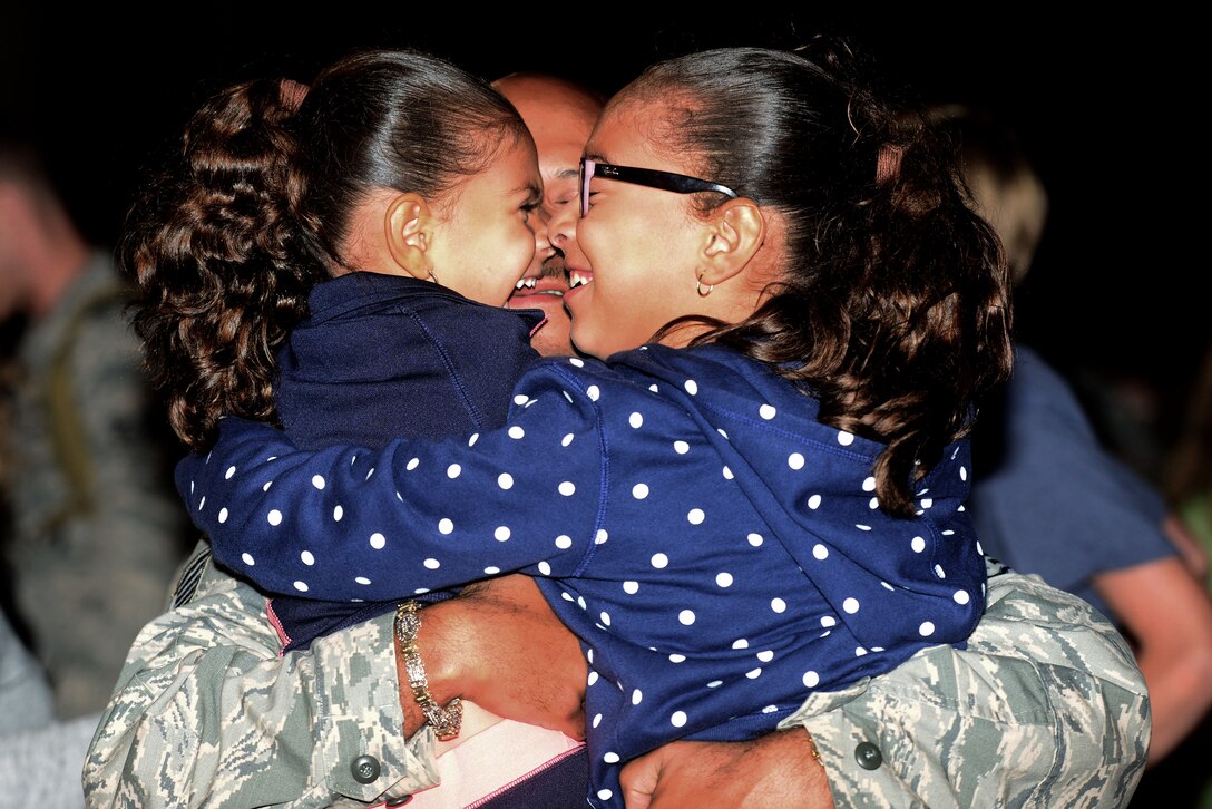 A U.S. Air Force Airman hugs his daughters after returning from a six-month deployment to the Middle East in support of Operation Inherent Resolve at Langley Air Force Base, Oct. 5, 2015. The 94th and 149th Fighter Squadrons were augmented by men and women of the Virginia Air National Guard’s 192nd FW and the 633rd Air Base Wing. (U.S. Air Force photo by Airman 1st Class Derek Seifert/ Released)
