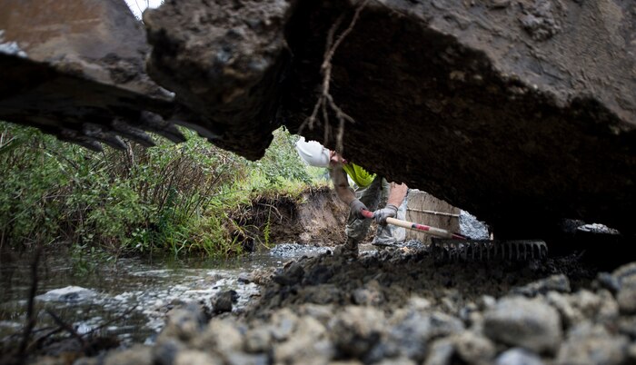 Staff Sgt. Devin Kennedy, 628th Civil Engineer Squadron heavy equipment operator, makes room for a sewer cover to be placed Oct. 6, 2015, on a road on Joint Base Charleston – Weapons Station, S.C. While hurricane Joaquin did not make landfall on the east coast, a constant flow of heavy rain caused flooding throughout the Carolinas. The 628th CES quickly accessed the damage and took action to fix and restore base assets. (U.S. Air Force photo/Airman 1st Class Clayton Cupit)