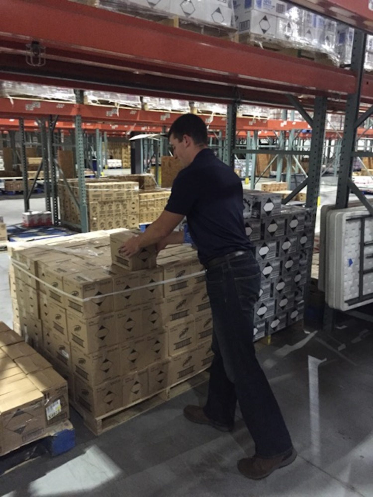 Cadet 1st Class Matthew Sprague handles boxes in a warehouse at Walmart headquarters in Bentonville, Arkansas. Sprague worked with WalMart officials and employees during his Cadet Summer Research Program to study and improve the distribution center's productivity levels. (Courtesy photo)