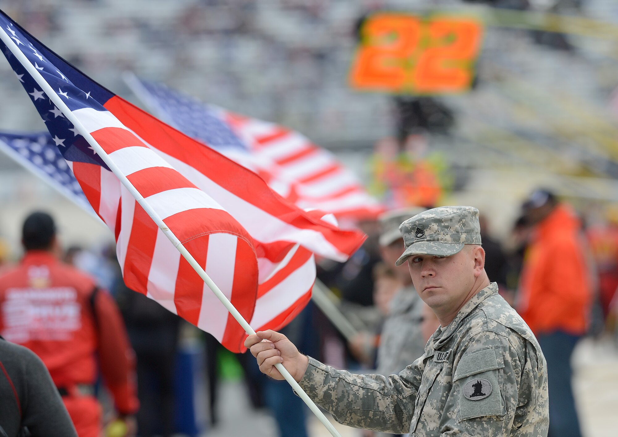 Staff Sgt. Michael Karr, 198th Signal Battalion, Delaware Army National Guard, leads a line of military members from various services holding American flags in pit-road during the opening ceremonies of the 2015 AAA 400 NASCAR Sprint Cup Series race Oct. 4, 2015, at Dover International Speedway in Dover, Del. Karr is a multichannel communications operator with the New Castle based unit. (U.S. Air Force photo/Greg L. Davis