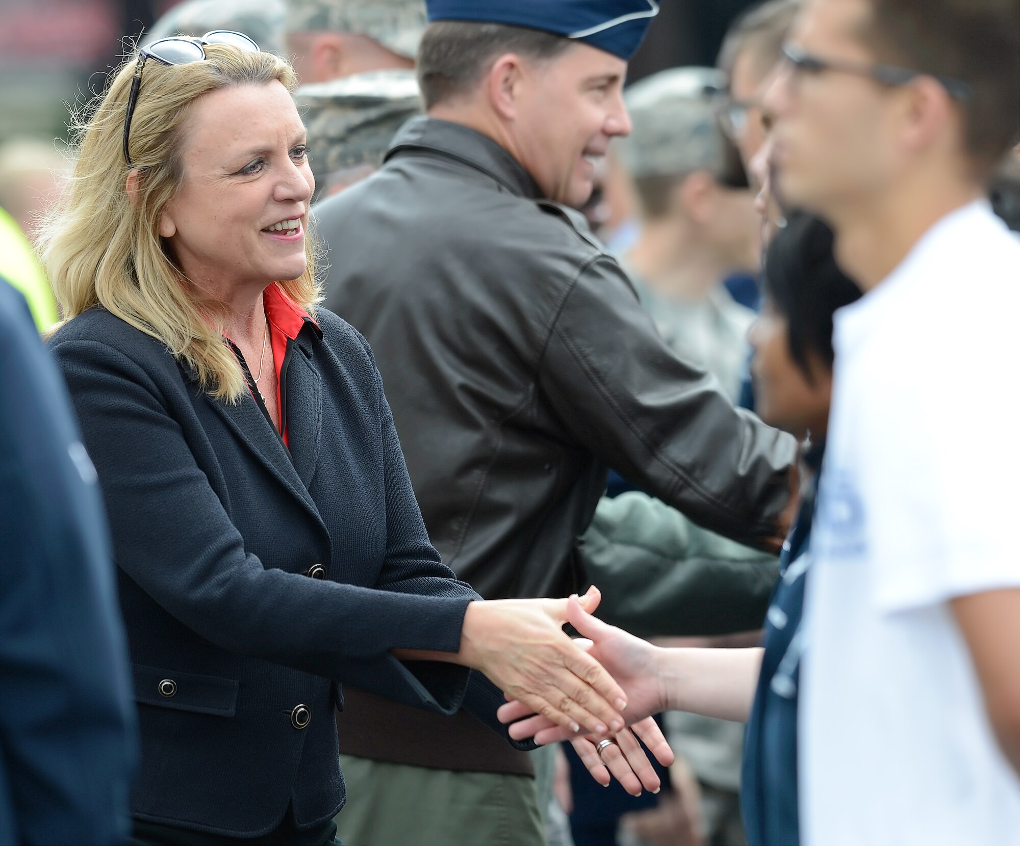 Secretary of the Air Force Deborah Lee James shakes the hands of new enlistees after a mass swearing-in-ceremony during pre-race ceremonies for the 2015 AAA 400 NASCAR Sprint Cup Series race Oct. 4, 2015, at Dover International Speedway in Dover, Del. Secretary James was the honorary pace car driver for the start of the race. (U.S. Air Force photo/Greg L. Davis)