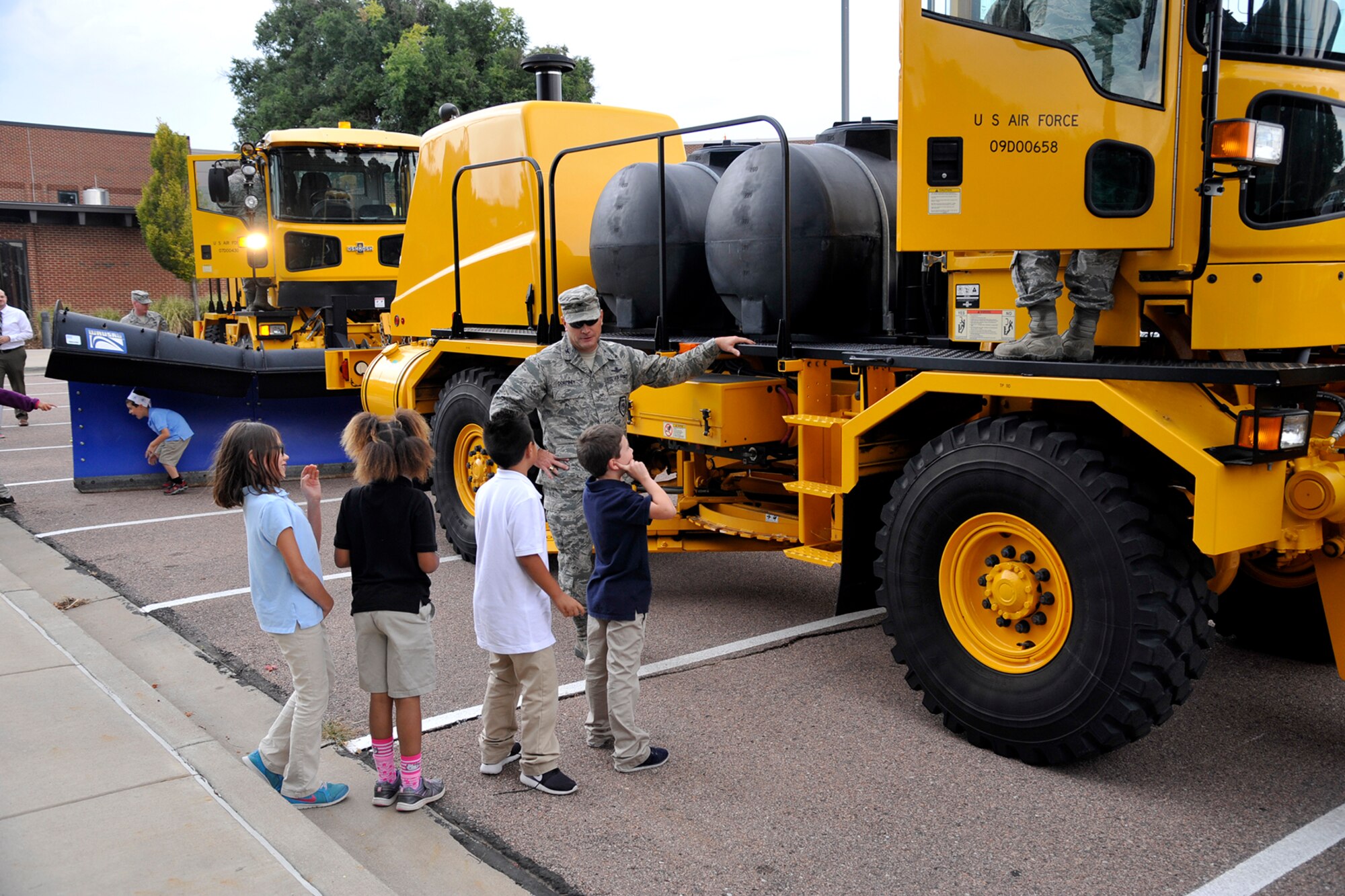 PETERSON AIR FORCE BASE, Colo. – Col. Eric Dorminey, 21st Space Wing vice commander, visits with children at the R.P. Lee Youth Center during the annual “Snow Parade” down Peterson Boulevard on Sept. 29, 2015. The parade visited children at the Child Development Centers and youth center and let them explore the machinery. The annual parade is a way to show off the CES equipment and crews who work to make Peterson roadways safe and emphasize the need to keep roadways clear and accessible for emergency vehicles. (U.S. Air Force photo by Robb Lingley)