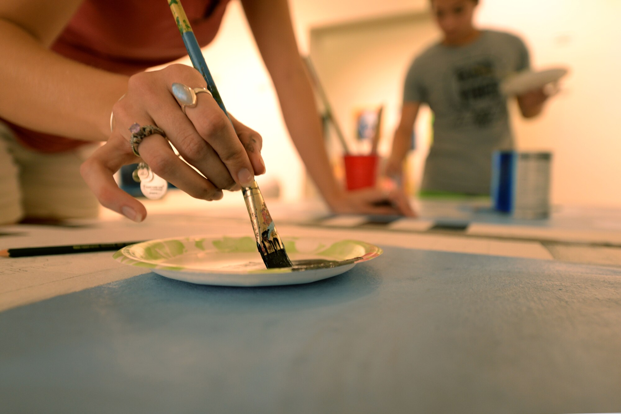 Heather Reynolds, gallery director at the Arts Council of Wayne County, dabs her brush into paint, Sept. 21, 2015, in downtown Goldsboro, North Carolina. Members of the Seymour Johnson Air Force Base Painting Club partnered with members of the Arts Council for a 5-day event, Sept. 21-26, to help beautify certain sections of downtown Goldsboro. (U.S. Air Force photo/Airman 1st Class Ashley Williamson)