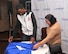 Sally Truhitte, Joint Base San Antonio business operations specialist, helps Neil Magny, currently ranked 12th in the Ultimate Fighting Championship’s welterweight division, fold T-shirts that were given out to Team Offutt personnel during Fight Night Oct. 3, 2015, at the Patriot Club, Offutt Air Force Base, Neb. Offutt was one of just three bases to host a UFC fighter for UFC 192. (U.S. Air Force photo by D.P. Heard/Released)