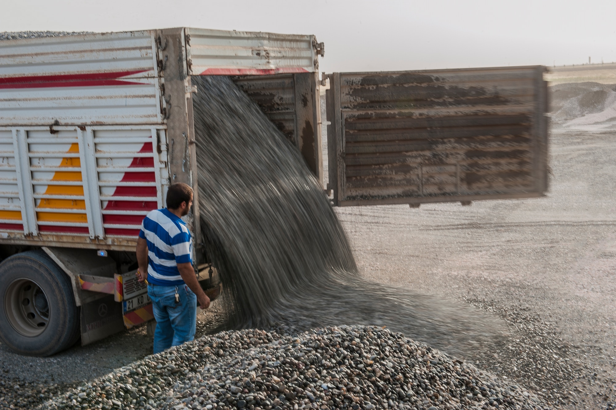 A Turkish national unloads gravel to be used as a foundation for building structures Sept. 15, 2015 at Diyarbakir Air Base, Turkey. Personnel from the 435th Contingency Response Squadron worked with local Turkish contractors to build and lay the foundation for the base where U.S. personnel will be deployed and operating from. Diyarbakir Air Base is a Turkish base home to the Turkish air force's 8th Air Wing. (U.S. Air Force photo by Airman 1st Class Cory W. Bush/Released)