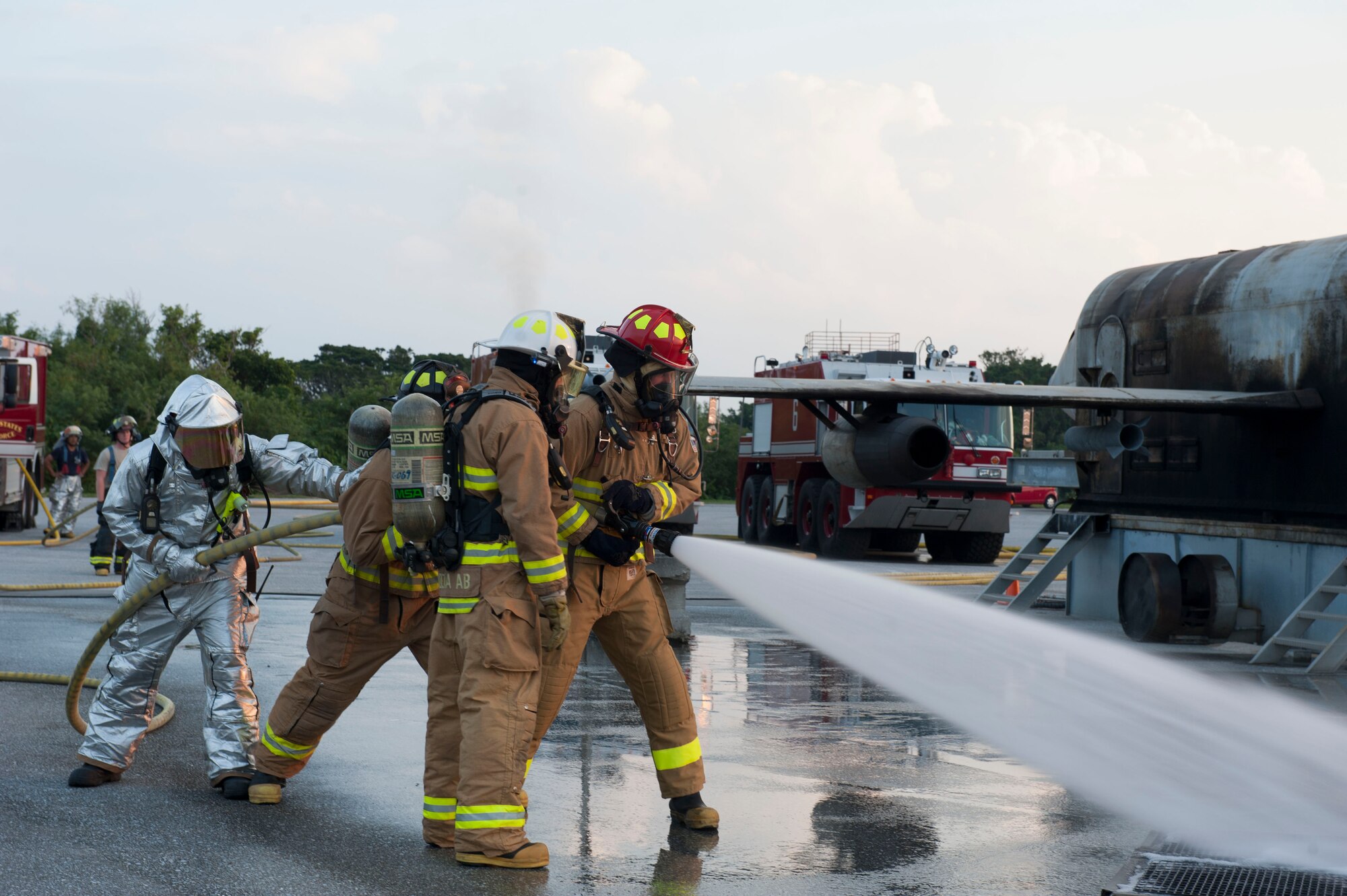 U.S. Air Force Col. John Cotton, 18th Medical Group deputy commander, Staff Sgt. Reginald Bramlett, 18th Civil Engineer Squadron crew chief, and Airman 1st Class Trent O’Shell, 18th CES firefighter, put out a fire during a live fire demonstration Oct. 6, 2015, on Kadena Air Base, Japan. Kadena’s wing leadership learned how to successfully put out fires as part of a training demonstration.  (U.S. Air Force photo by Airman 1st Class Lynette M. Rolen)