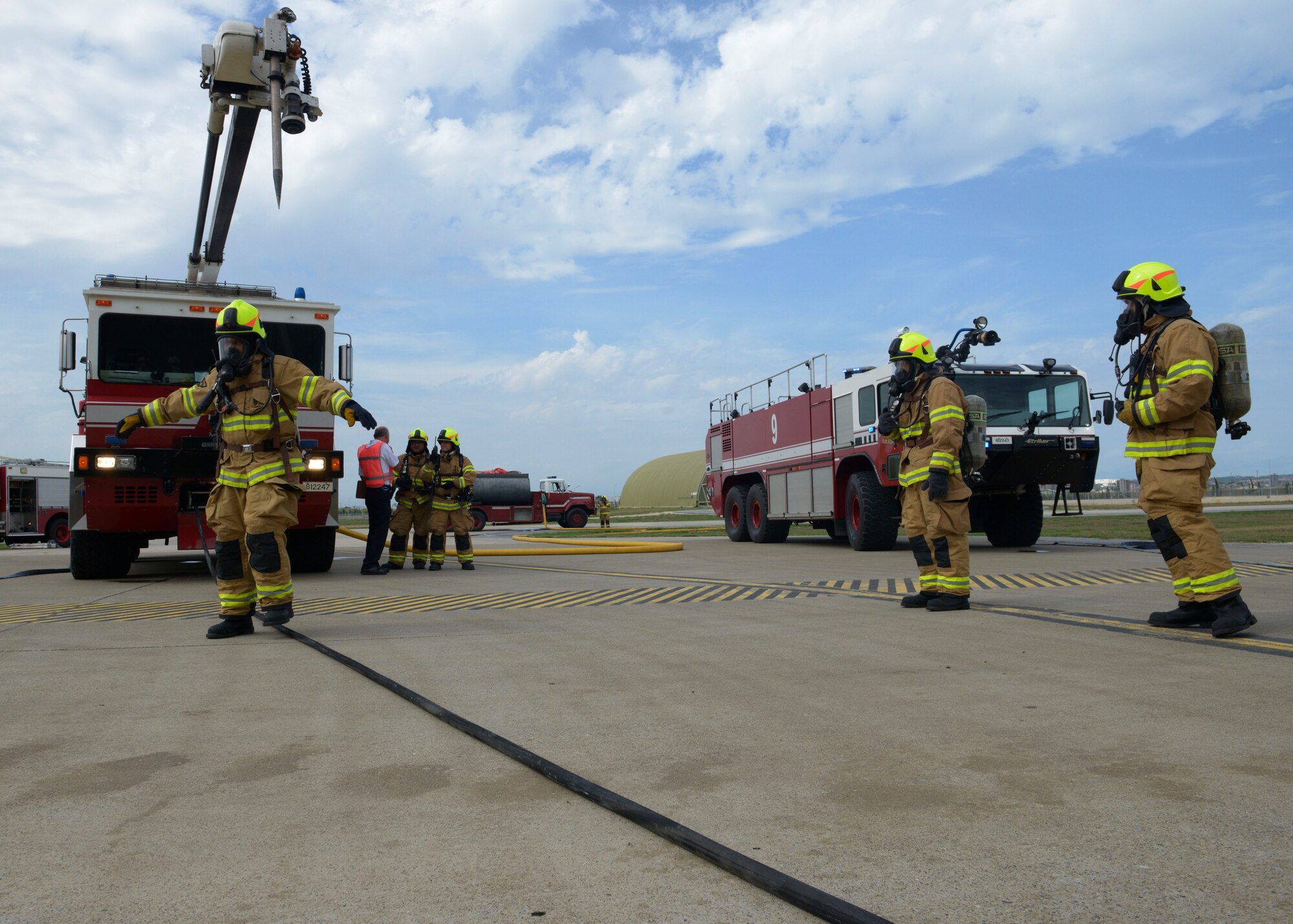 Firefighters from the 39th Civil Engineer Squadron proceed through a mock decontamination shower after responding to a simulated fire during a wing-wide exercise Oct. 2, 2015, at Incirlik Air Base, Turkey. The firefighters participated in the exercise to hone their skills and get real world practice responding to a fire inside of a protective aircraft shelter. (U.S. Air Force photo by Senior Airman Krystal Ardrey/Released)