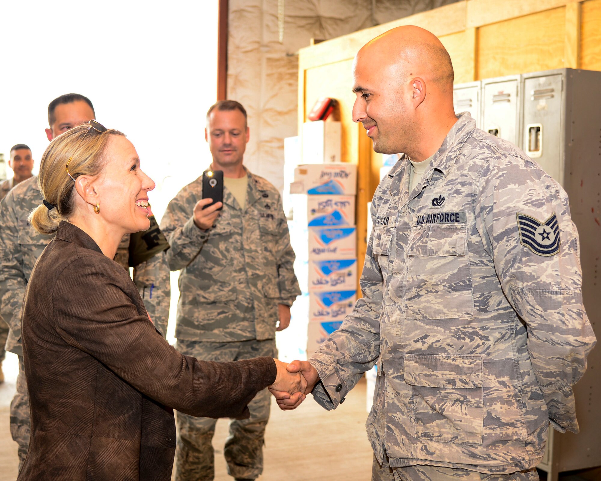 Miranda A.A. Ballentine, Assistant Secretary of the Air Force for Installations, Environment and Energy, Headquarters U.S. Air Force, the Pentagon, Washington, D.C. coins Tech. Sgt. Alberto Aguilar, 386th Civil Engineer Squadron electrical power production craftsman, during a visit at an undisclosed location in Southwest Asia, Oct. 6, 2015. Ballentine traveled to the area of responsibility to get hands-on experience in a deployed environment and hear directly from the Airmen about their concerns. (U.S. Air Force photo by Senior Airman Racheal E. Watson/Released)