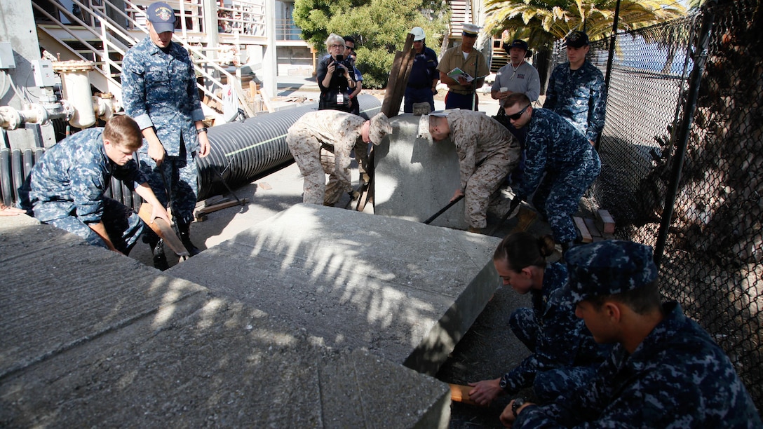 Marines and sailors lift concrete blocks using wooden blocks and pry bars during urban search and rescue training at Treasure Island, Oct. 7, 2015, as part of San Francisco Fleet Week 2015. The event featured demonstrations and hands-on training with tools commonly used for rescue missions during disaster relief.