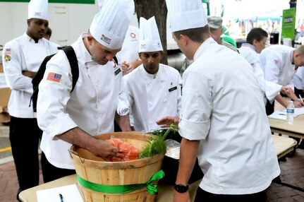 Staff Sgt. Markos A. Mendoza, 311th Sustainment Command (Expeditionary), sorts through items in the mystery basket while Sgt. Jeffrey W. Vaughan, 310th Sustainment Command (Expeditionary), the team captain for the Army Reserve Culinary Arts Team, discusses menu development with the team. 