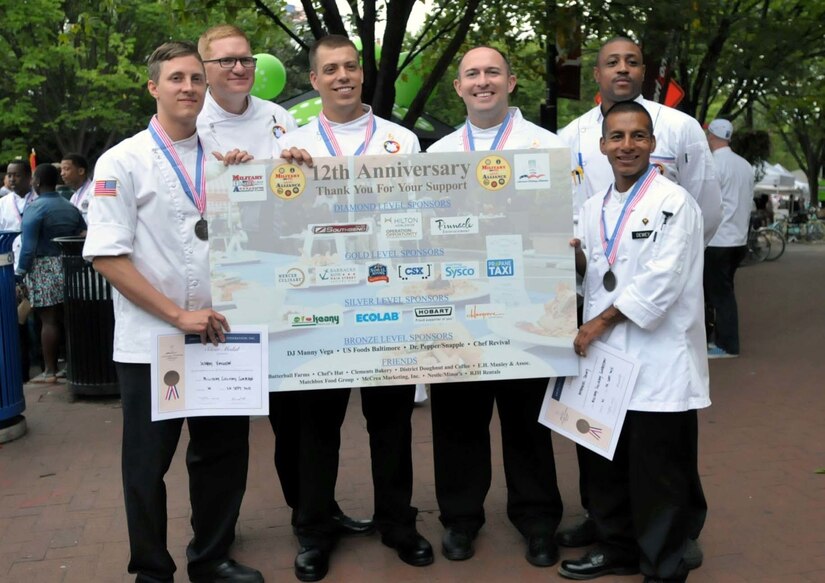 The Army Reserve Culinary Team poses for a photograph with their coach, Chief Warrant Officer 2 Colby S. Beard, 807th Medical Command and runner, Spc. Jason L. Brye, 4th Sustainment Command (Expeditionary), after receiving their silver medals and official certificates from the American Culinary Federation Inc. at the Military Culinary Competition held during the Barracks Row Fall Festival in Washington, Sept. 26, 2015. This is the ninth year that the Army Reserve Culinary Team has competed at this event. 
