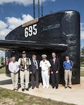 Former members of the USS Birmingham submarine stand next to the ships’ sail with Rear Adm. John King, DLA Land and Maritime commander, Sept. 23 after the ribbon cutting ceremony to open the brand new Mission Park on Defense Supply Center Columbus. A fitness trail links land and sea vehicles, weapons systems and historic displays that reflect DSCC’s contributions to the nation’s defense since 1918 at the park.