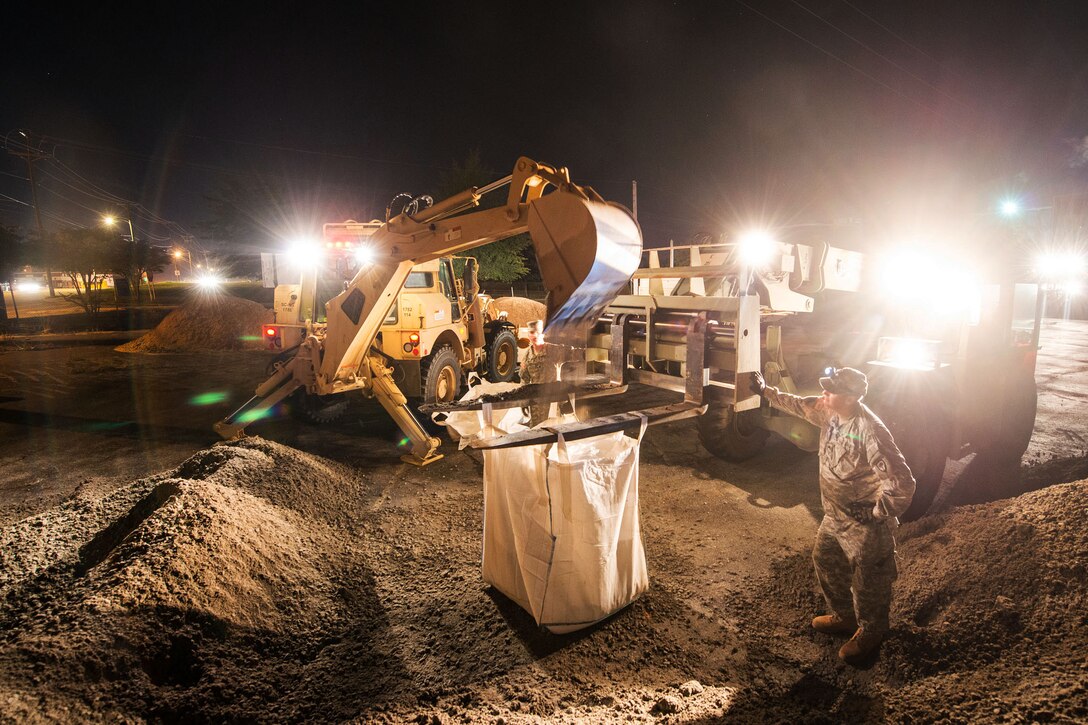 South Carolina Army National Guardsmen fill sandbags to use at the breached canal at the Riverfront Canal Park in Columbia, S.C., Oct. 6, 2015. The South Carolina National Guard has been activated to support state and county emergency management agencies and local first responders as historic flooding impacts counties statewide. South Carolina National Guard photo by Air Force Tech. Sgt. Jorge Intriago