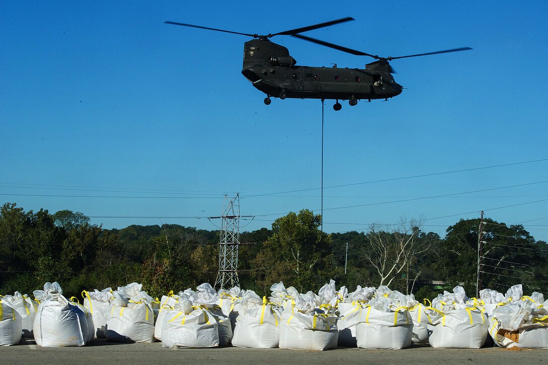 South Carolina Army National Guardsmen use a CH-47 Chinook helicopter to deliver sandbags to dam the breached canal at the Riverfront Canal Park in Columbia, S.C., Oct. 7, 2015. The soldiers are assigned to the 2nd Battalion, 238th Aviation Regiment. The South Carolina National Guard has been activated to support state and county emergency management agencies and local first responders as historic flooding impacts counties statewide. South Carolina National Guard photo by Air Force Tech. Sgt. Jorge Intriago