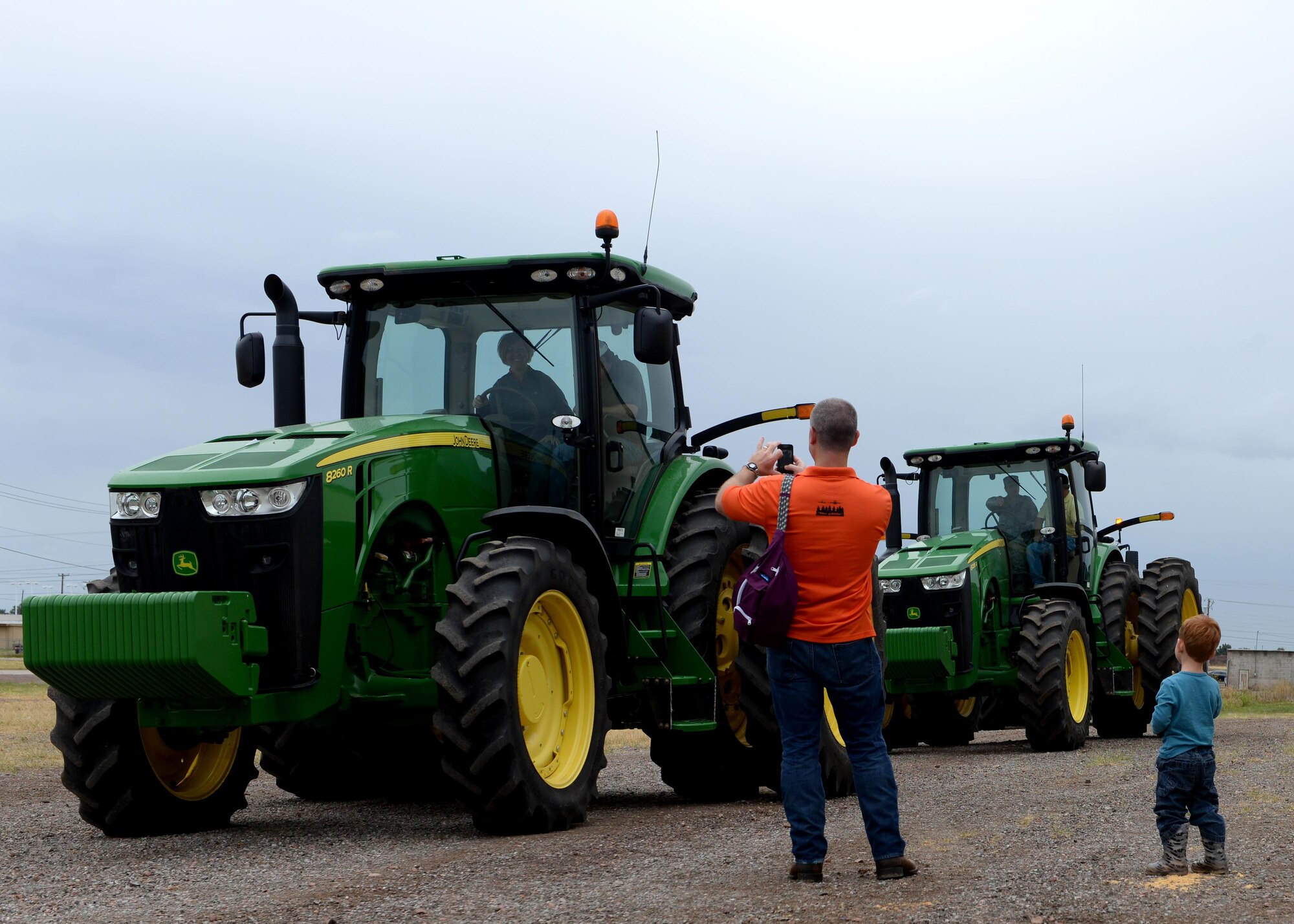 ALTUS AIR FORCE BASE, Okla. – U.S. Air Force Lt. Col. Brian Collins, 97th Operation Support Squadron commander and his son, watch as Airmen learn how to drive tractors during a Farm City tour, October 5, 2015. Altus Air Force Base Airmen and their families got the opportunity to tour local farms and learn agriculture processes. (U.S. Air Force photo by Airman 1st Class Nathan Clark/Released)