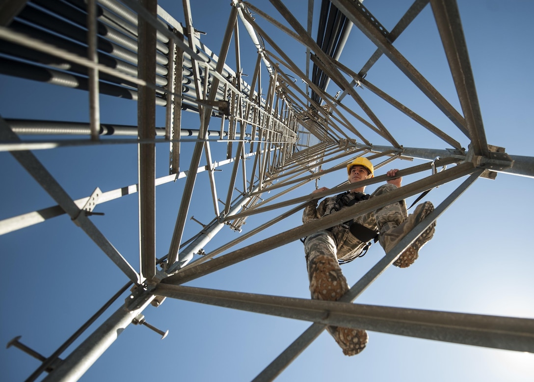 Air Force Senior Airman James Vrtis descends a ground-to-air radio tower at the airfield systems maintenance compound on Nellis Air Force Base, Nev., Oct. 6, 2015. Vrtis is an airfield systems technician with the 57th Operations Support Squadron. U.S. Air Force photo by Staff Sgt. Siuta B. Ika